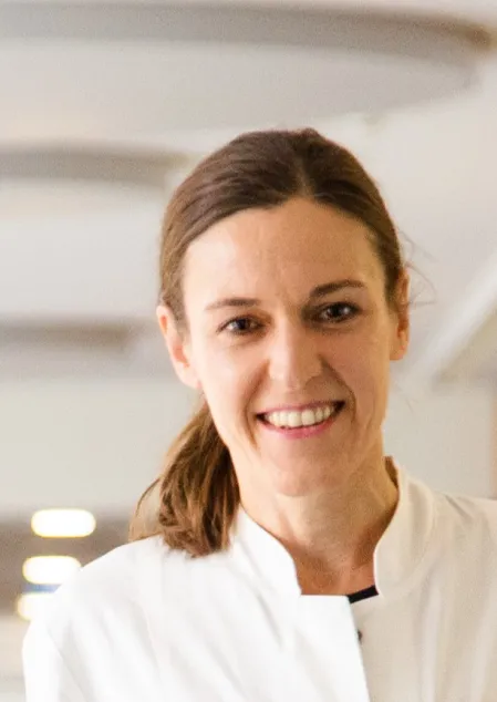 Prof. Dr. Barbara Ludwig tr&auml;gt einen Arztkittel, sie l&auml;chelt in die Kamera.