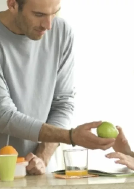 Mann gibt Kind einen Apfel Mann gibt Kind einen Apfel