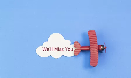 Rotes Flugzeug auf blauem Hintergrund, Text "We'll miss you"