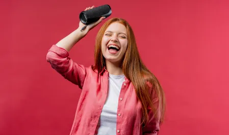 Junge Frau mit Lautsprecher in der Hand