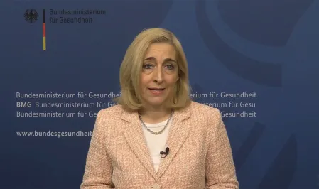 Bundesgesundheitsministerin Nina Warken vor einem blauen Hintergrund