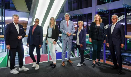 Ein Gruppenbild des Vorstands von diabetesDE vor einem dunklen Hintergrund mit Lichtern