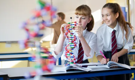 Zwei M&auml;dchen in Schuluniform im Chemieunterricht 