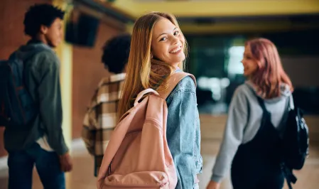 M&auml;dchen mit Schulrucksack l&auml;uft mir ihren Freund*innen