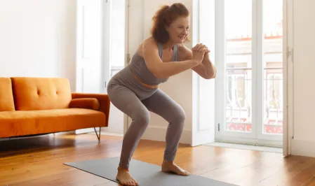 Frau macht zu Hause Kniebeuge