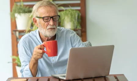 Älterer Mann arbeitet am Laptop