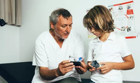 Arzt erklärt einem Kind Diabetes-Technik