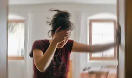 Einer jungen Frau ist schwindelig, verschwommener Hintergrund