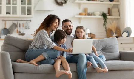 Familie sitzt vor einem Laptop